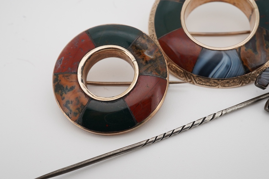 Two Scottish hardstone brooches and a stick pin, late 19th century, the brooches of annular design, the stick pin of horseshoe design, each inlaid with panels of jasper and bloodstone, largest brooch 4cm diameter, combin